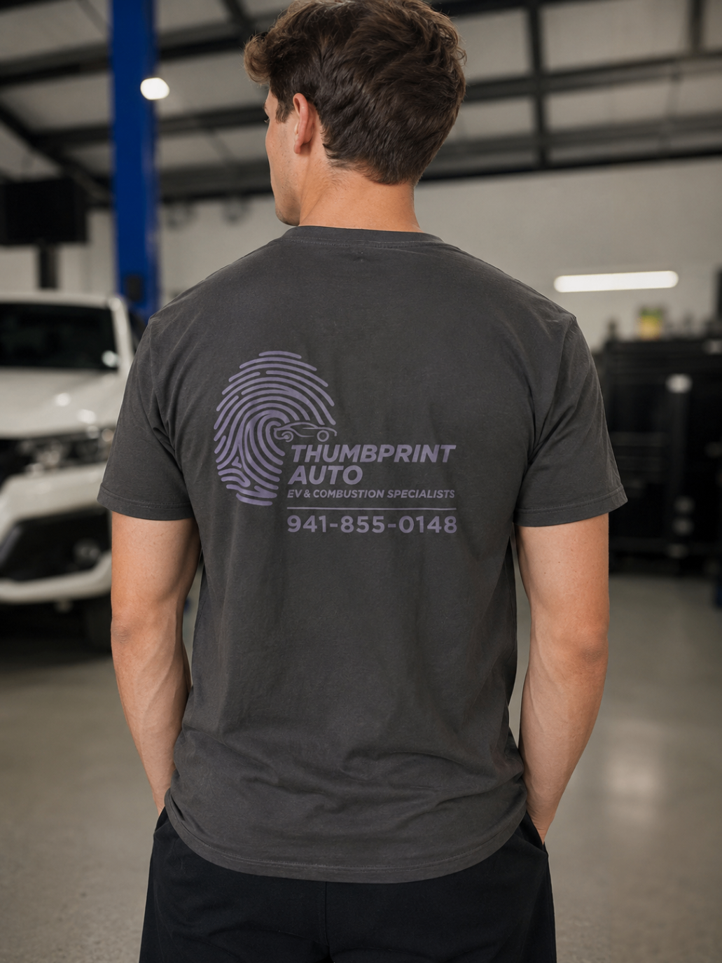 Back view of a dark custom t-shirt with Thumbprint Auto branding.